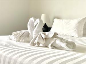 a bed with white towels on top of it at Casa Del Sole Apartments in Noumea