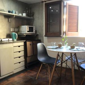 eine Küche mit einem Tisch, Stühlen und einer Mikrowelle in der Unterkunft Casa Salta in Corrientes