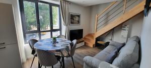 salon ze stołem i kanapą w obiekcie LES APPARTEMENTS DE LA B w mieście Saint-Benoît-des-Ondes