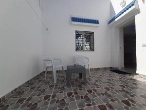 a room with two chairs and a table on a stone floor at Dar salah in Hammamet