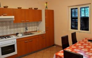 a kitchen with wooden cabinets and a table and a sink at Apartments by the sea Prozurska Luka, Mljet - 619 in Prožura