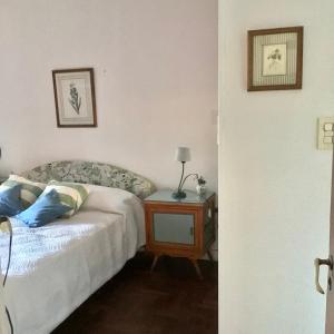 1 dormitorio con 1 cama y 1 mesa con lámpara en Casa Salta en Corrientes