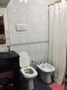 a bathroom with a white toilet and a sink at Casa Salta in Corrientes