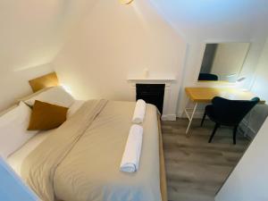 een slaapkamer met een bed met een bureau en een bureau bij Cosy flat in London in Londen