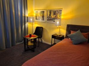 une chambre d'hôtel avec un lit, une table et des chaises dans l'établissement Noah Longstay, à Västerås