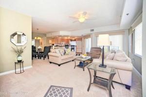 a living room with a couch and a table at Lovely & Cozy 3 bedroom with pool in New Smyrna Beach