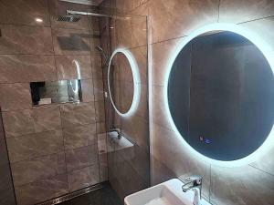 a bathroom with a round mirror and a sink at Pipers Lodge in National Park