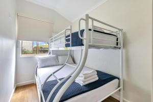 Darwin FreeSpirit Resort في داروين: سرير بطابقين في غرفة صغيرة مع سرير بطابقين