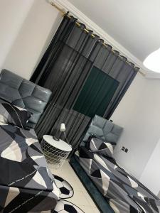 Cette chambre comprend un lit, une table et une fenêtre. dans l'établissement Magnifique appartement proche Arribat Center, à Rabat