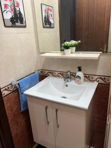 Un baño con un lavabo blanco y un espejo. en Magnifique appartement proche Arribat Center, en Rabat