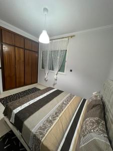 - une chambre avec un grand lit et une fenêtre dans l'établissement Magnifique appartement proche Arribat Center, à Rabat