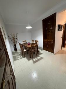 Un comedor con mesa y sillas de madera. en Magnifique appartement proche Arribat Center, en Rabat 1 foto más