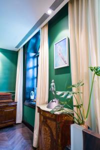 ein grünes Zimmer mit einem Waschbecken und einem Fenster in der Unterkunft Gracie Art Hotel in Peking