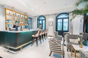 un restaurante con un bar con mesas y sillas en Gracie Art Hotel, en Beijing