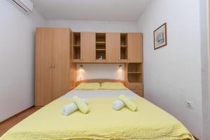een slaapkamer met een groot geel bed met 2 kussens bij Studio Brela 6907c in Brela