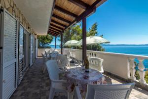 een patio met een tafel en stoelen en de oceaan bij Seaside secluded apartments Cove Torac, Hvar - 575 in Gdinj