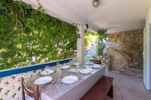 een tafel met borden en wijnglazen erop bij Seaside secluded apartments Cove Torac, Hvar - 575 in Gdinj