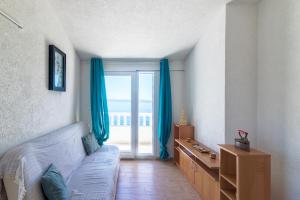 a bedroom with a bed and a window with blue curtains at Seaside secluded apartments Cove Torac, Hvar - 575 in Gdinj