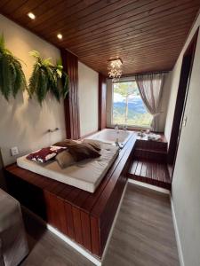 een slaapkamer met een bed en een bad bij Pousada Hinckel in Alfredo Wagner