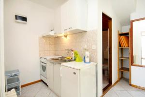 cocina blanca con fregadero y nevera en Apartments by the sea Hvar - 591, en Hvar