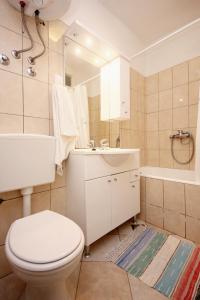 a bathroom with a toilet and a sink and a tub at Apartments by the sea Viganj, Peljesac - 633 in Viganj