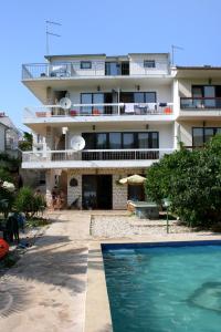- un grand bâtiment avec une piscine en face dans l'établissement Family friendly apartments with a swimming pool Stari Grad, Hvar - 583, à Stari Grad
