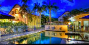 a villa with a swimming pool at night at Rainbow Beach Dream Newly Renovated Stylish One Bedroom Apartment in Rainbow Beach