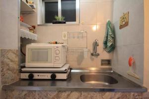 eine Küchentheke mit Mikrowelle und Spüle in der Unterkunft Apartamento Copacabana 229 in Rio de Janeiro