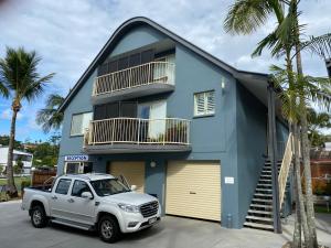 a truck parked in front of a blue house at Rainbow Beach Dream Newly Renovated Stylish One Bedroom Apartment in Rainbow Beach