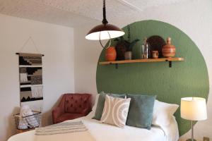 a bedroom with a green wall and a bed with pillows at CASA MADERA in Lagos de Moreno