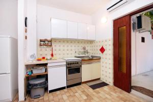 a kitchen with white cabinets and a stove top oven at Apartments by the sea Brna, Korcula - 560 in Smokvica
