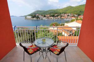 a table and chairs on a balcony with a view of the water at Apartments by the sea Brna, Korcula - 574 in Smokvica