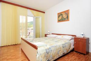 a bedroom with a bed and a window at Apartments by the sea Brna, Korcula - 574 in Smokvica