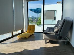 uma sala de estar com um sofá e uma cadeira em Joy Villa Flamingo Đại Lải - 5 phòng ngủ em Phúc Yên