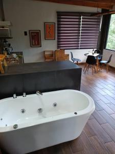 uma grande banheira branca num quarto com uma mesa em Mazamitla Pinos del Rio em Mazamitla