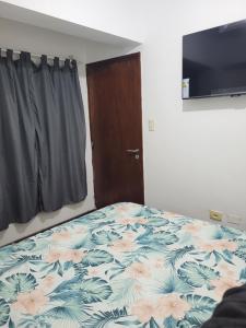 a bedroom with a bed with a flower pattern on it at Departamento Calle San Martin ( Microcentro) in San Miguel de Tucumán