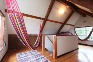 a bedroom in a tiny house with red curtains at 陽のあたる宿 サンセットパーム in Oshima