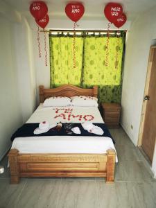 Un dormitorio con una cama con letreros rojos. en Hotel Ríos de Jamaica, en San Rafael