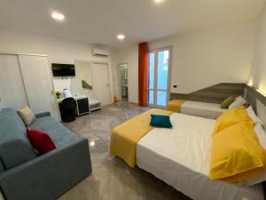 pokój hotelowy z 2 łóżkami i kanapą w obiekcie Oasi nel Deserto w mieście Custonaci