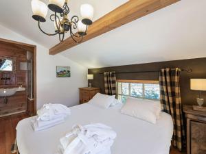 a bedroom with a white bed with towels on it at Chalet Saint-Martin-de-Belleville, 4 pièces, 8 personnes - FR-1-570-17 in Saint-Marcel