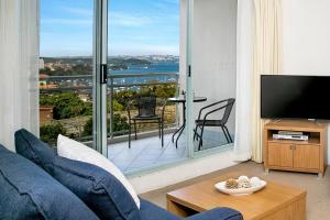 a living room with a blue couch and a large window at ALF49-Huge 2BR Penthouse Style, Great Water Views in Sydney