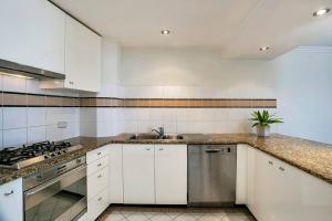 雪梨的住宿－ALF49-Huge 2BR Penthouse Style, Great Water Views，厨房配有白色橱柜和水槽
