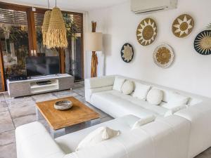 a living room with a white couch and a tv at AB Villa & Apartments in Seminyak