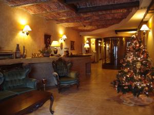 a living room with a christmas tree in a lobby at Hotel Bella Muzica in Braşov