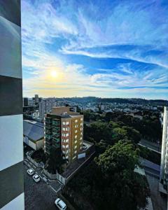 una vista de una ciudad con el sol en el cielo en Apartamento temático luxo Mundo do Vinho!, en Bento Gonçalves