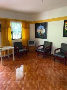 - un salon avec des chaises, une table et une télévision dans l'établissement Finca del profe, à Santa Fe de Antioquia