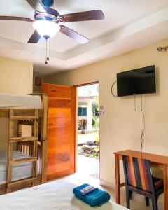 a bedroom with a bed and a flat screen tv at Casa Inti Guesthouse & Lodge in Managua
