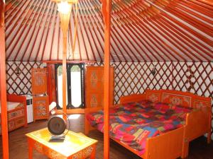 sypialnia w jurcie z łóżkiem i stołem w obiekcie Superb yurt of Mongolian tradition in Provence w mieście Sarrians