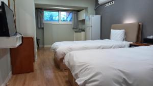 Cette chambre comprend 2 lits et une télévision à écran plat. dans l'établissement Hotel Jirisan Haetsal, à Gurye