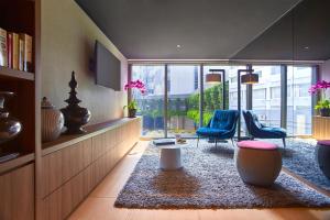 a living room with two chairs and a table at Pan Pacific Serviced Suites Beach Road, Singapore in Singapore